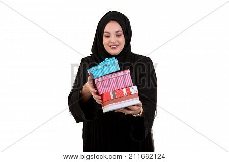 Happy young muslim woman with shopping bag and gift boxes isolated over white background.
