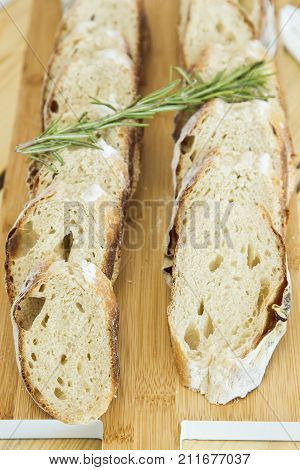 fresh french bread sliced on a wooden platter unsliced and ready to eat