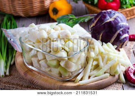 Frozen vegetables on a wooden cutting board. Frozen cabbage kohlrabi