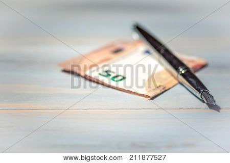 Journalists bribery concept with pen and banknote.