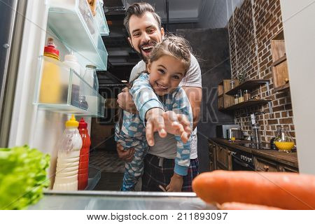 Father With Daughter Trying To Reach For Food