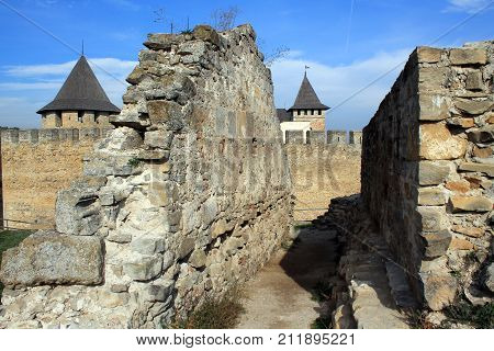 Ruins of ancient wall on background of medieval fortress in Khotyn.