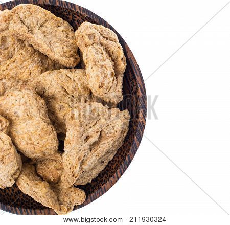 Dry soy slices of meat in wooden plate on white background. Studio Photo