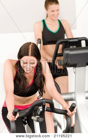 Fitness mladá dívka na kole v tělocvičně