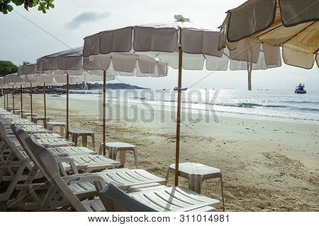 Landscape View Of Sea Beach In The Morning, Beach Umbellas And Bench On Seaside With Green Tree, Sum