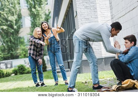 African American Boy In Hoodie And Jeans Bulling Boy And Teenager Shooting It And Pointing With Fing