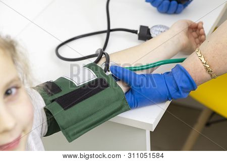 The Doctor Measures The Blood Pressure Of The Child With A Tonometer. Preventive Measures