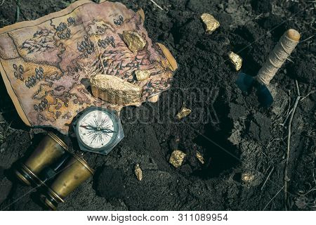 Treasure Map, Compass, Binoculars And Golden Nuggets On A Ground. Treasure Hunt Concept Background.