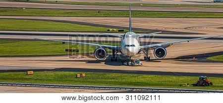 A Modern Commercial Aircraft Being Towed Across Runways At An Airport