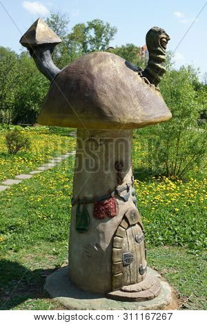 Mytishchi, Russia - September 2016: Magic worm in a dwarf mushroom house. Small fabulous skulpture in the city park.