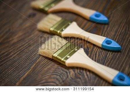 Painting Tools On Craft Wooden Background. New Brushes