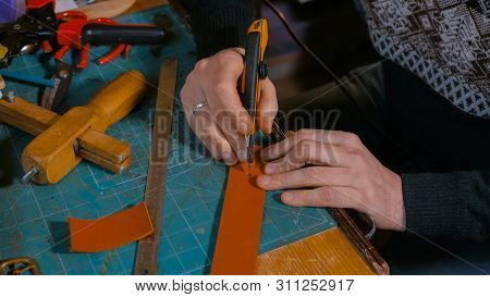 Professional Male Skinner, Tanner Working With Genuine Leather Belt At Workshop, Studio. Handmade An