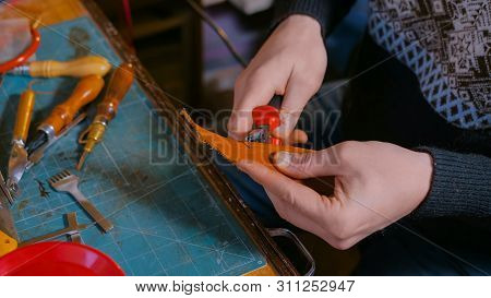 Professional Male Skinner, Tanner Working With Genuine Leather Belt At Workshop, Studio. Handmade An