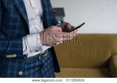 Close-up Of A Man Who Holds In His Hand A Smartphone . He Is Standing Im Loft Interior . Business Pe
