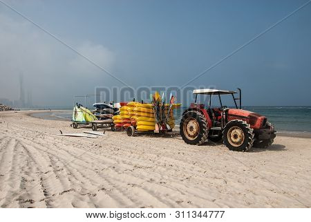 Tractor With Trailer Full Of Yellow Kayaks, Standing On The Beach, Caesarea, Israel. Orot Rabin, A C