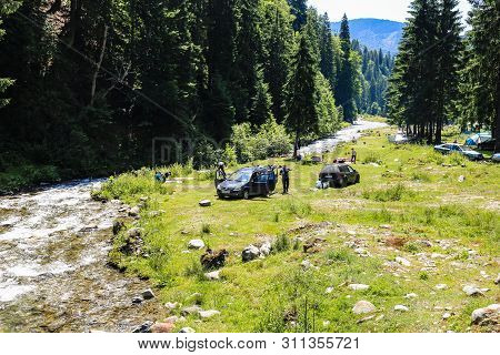 Iezer Mountains - Romania - 2019. People Relaxing Next To A River, And Having Barbeque.
