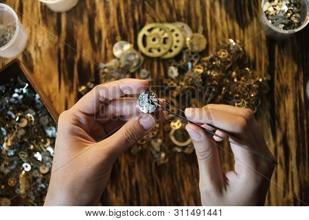 Girl Craftsman Dismantles Clock Shoot Close Up. Female Hands Holding Tweezers. Repairing Vintage Wat