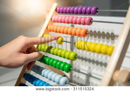 Male Hand Calculating With Beads On Wooden Rainbow Abacus For Number Calculation. Mathematics Learni