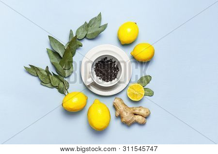 Creative Food Concept. Fresh Ginger Root, Cup Tea With Brewing Inside, Lemon, Eucalyptus Leaves On B