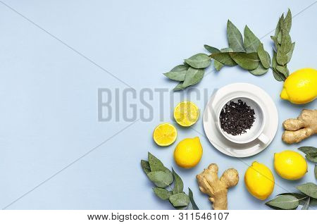 Creative Food Concept. Fresh Ginger Root, Cup Tea With Brewing Inside, Lemon, Eucalyptus Leaves On B