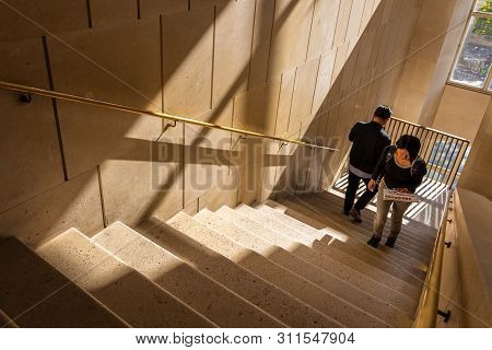 Paris, France - September 30, 2018: Man And Woman Walking On Old Mable Stair Brighten Up By Sunlight
