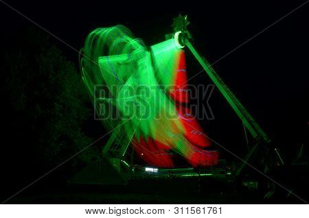 Extreme Attraction In Lunapark, With A Multi-colored Red And Green Lights, A Long Exposure Shooting