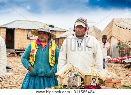 Uros, Peru- Jan 5, 2019: Inhabitants of Uros floating islands in traditional costumes, Titicaca lake, Peru.
