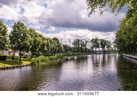 Sluis, The Netherlands -  June 16, 2019: Reflecting Water Of Canal To Damme In Belgium, With Curtain