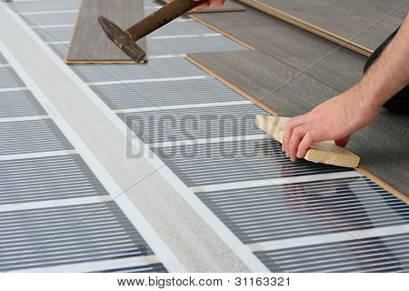 Uomo installazione pavimento laminato sopra carbonio a raggi infrarossi, sistema di riscaldamento
