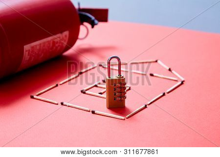 Fire Safety, Or Security And Protection Concept. A Fire Extinguisher, The Figure Of The House And Lo