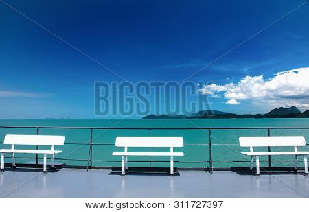 Three Chairs On The Deck Of The Sea 
With Blue Sky And The Sea