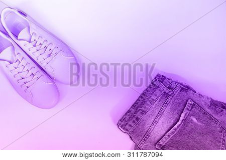 Flat Composition With A Set Of Clothes, Jeans And Pink Sneakers. Top View On A White Background. Neo
