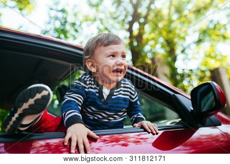 Crying Baby Boy In Car. The Boy Is Crying And Wants To Get Out Of The Maniche
