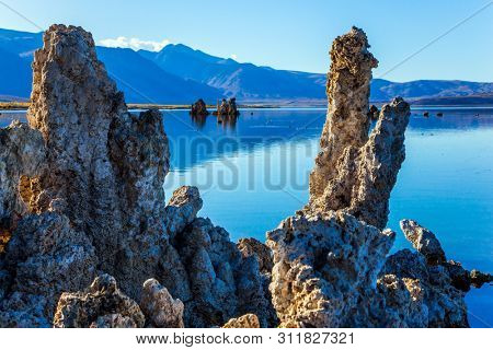 Natural Wonder of the World - Mono Lake. California, USA. Picturesque lake with lime-tuff towers of fancy shape. Evening by the lake. The concept of ecological, exotic and photo tourism