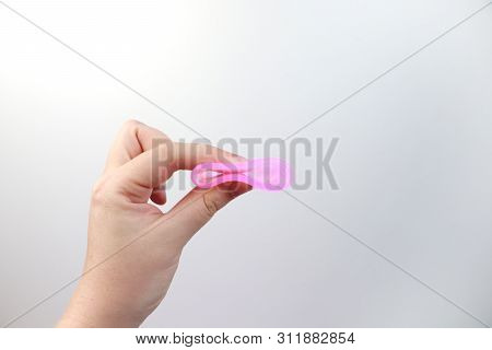 A Woman Holds A Menstrual Cup In Her Hand On A Pink Background. The Concept Of Women's Health, Hygie