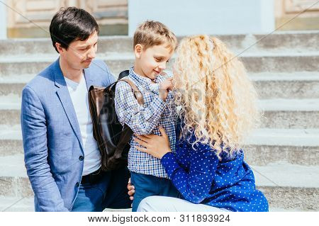 Enjoying Family Concept. Happy Mom And Dad Sending Their Child Pupil Boy First Time Studing To Schoo