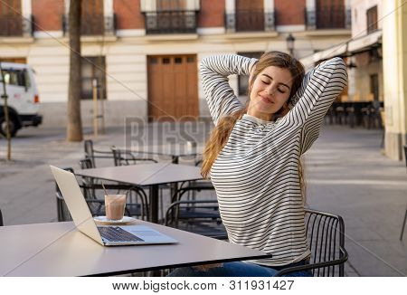 Happy Attractive Young Woman Working Or Studying In A Coffee Shop Outside With Laptop