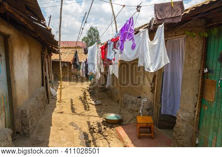 A Line Of Clean Clothes Dry Among The Dirty Mud And Clay Homes Of The Kibera Slum In Nairobi.