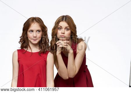 Cheerful Mom And Daughter Next To Red Dresses Hugs Lifestyle Light Background Smile