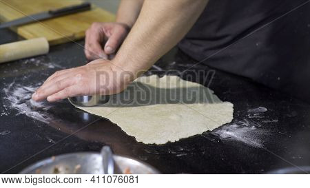 Cook Cutting Out Round Pieces Of Dough. Art. Close-up Of Professional Chef Preparing Dough For Dumpl