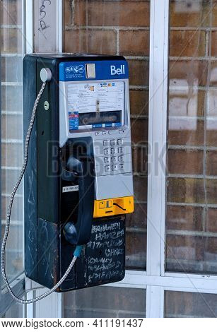 Ottawa, Ontario, Canada - February 6, 2021: A Worn Bell Canada Payphone With Graffiti In A Dirty Pho