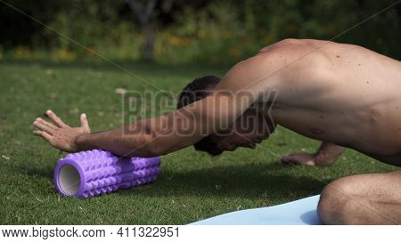 Young Caucasian Fit Attractive Male Exersicing Outdoors Trx Back Row Exercice With Green Vegetation 