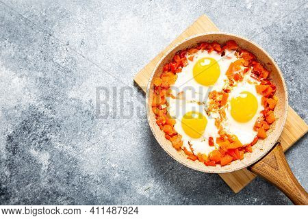 Tasty And Healthy Shakshuka In A Frying Pan. Eggs Poached In Spicy Tomato Pepper Sauce. Fried Eggs
