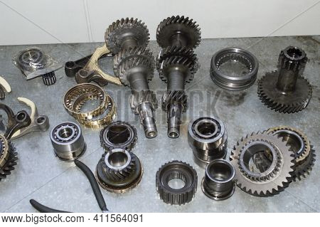 The Elements Of The Manual Transmission Of The Car Lie On A Metal Work Table In The Auto Repair Shop