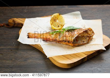Whole Baked Fish In Foil With Lemon. Fried Bass