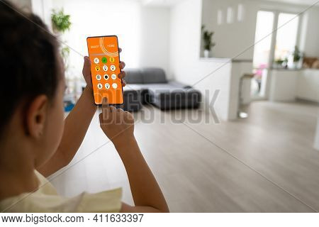 Shot Of Little Girl Using A Domotic System With Her Digital Tablet While Standing At Home.