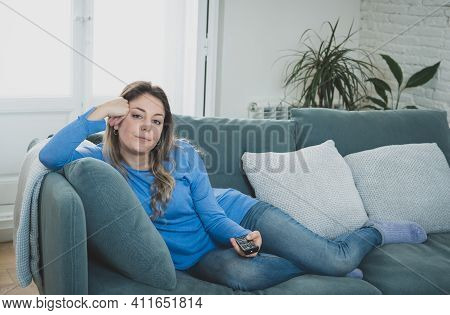 Bored Woman Watching Tv At Home Changing Channels With Remote Control