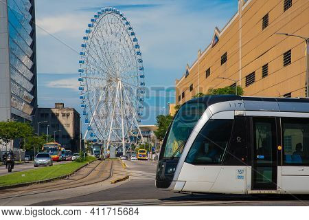 Rio De Janeiro, Brazil - January 7, 2021: Vlt Tram Is Passing In Front Of The Rio Star Ferris Wheel 