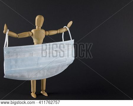 Disposable Face Mask For Health Care And For Helping Slow The Spread Of The Coronavirus. Wooden Figu