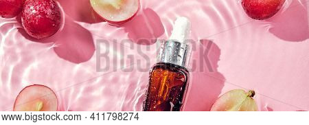 Skincare Cosmetic Product, Grapes And Water Splashes On Pink Banner. Organic Cosmetics With Grape Se